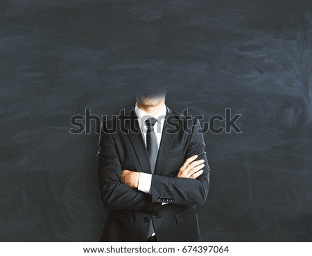 Abstract headless businessman with folded arms on chalkboard background