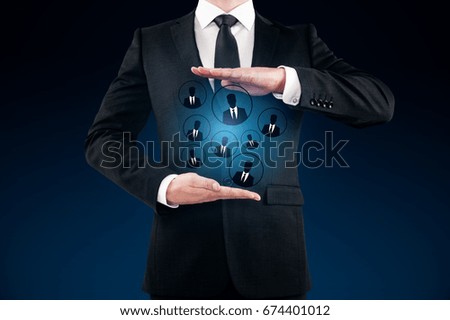 Businessman holding glowing HR hologram on dark blue background. Employment concept 