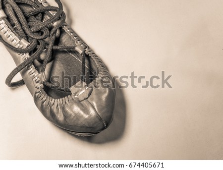 one basque dancing leather shoe close up on light brown background isolated top view