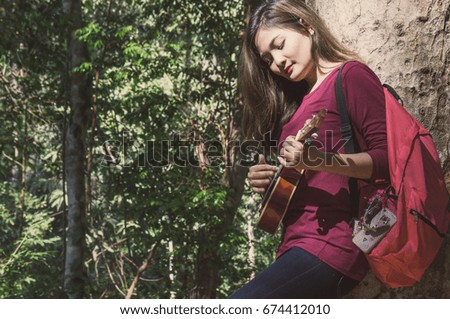 Asian woman feeling relax in forest with music