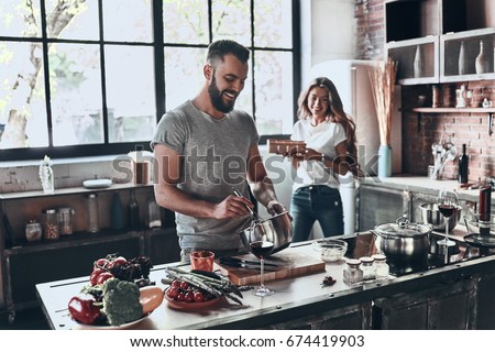 Secret ingredient is love. Beautiful young couple preparing a healthy meal together while spending free time at home Royalty-Free Stock Photo #674419903