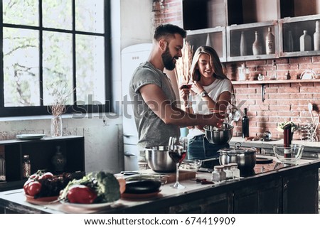 Recipe requires a lot of loving. Beautiful young couple preparing a healthy meal together while spending free time at home Royalty-Free Stock Photo #674419909