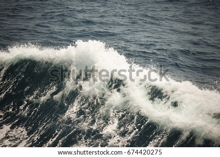 White crest of a sea wave. Selective focus. Shallow depth of field. Toned.