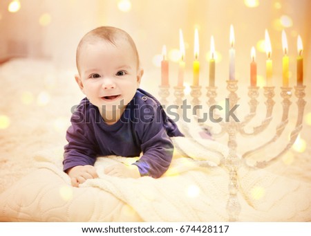 Little child on blurred festive lights background. Baby's First Hanukkah