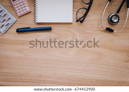 Top view of modern, sterile doctors office desk. Medical accessories on a wooden table background with copy space around products. Photo taken from above.