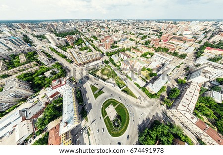 Aerial city view with crossroads and roads, houses, buildings, parks and parking lots, bridges. Helicopter drone shot. Wide Panoramic image.