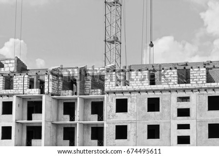 Construction site. Unfinished building with a crane and sky in background. Contemporary urban landscape. Vintage. Black and White Photography. Construction industry.