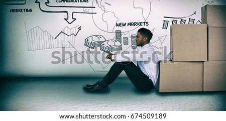 Businessman leaning on cardboard boxes against white background  against grey room