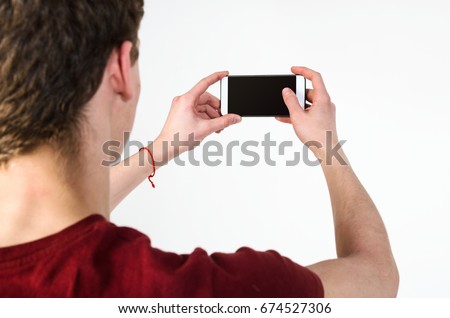 Young handsome man taking selfie on mobile phone camera