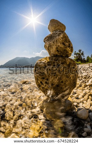 rock balancing by the sea with sun shining