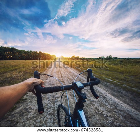 cyclist rides on the meadov dirt road on a Cyclocross bike. first-person view