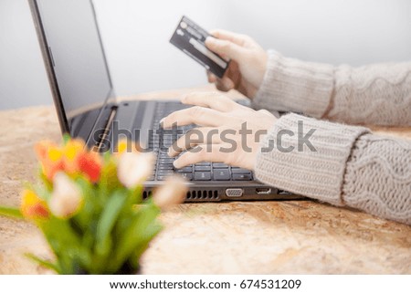 Shopping online Happy moments concept . Hand woman holding credit card and using laptop computer on the table .  Moments of pleasure for women. 