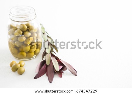Preservative olives in jar against white background