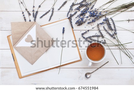Top view of a cup of tea, lavender, notebook and love letter on a white wooden background. Herbal Tea Letter Note Lavender Love