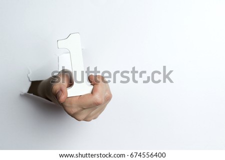 Female hand holding a number one white isolated background.