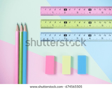 green, blue, pink eraser and eraser and pencils on green and light blue and pink background. 
beautiful colorful picture concept The same as the difference, minimal style