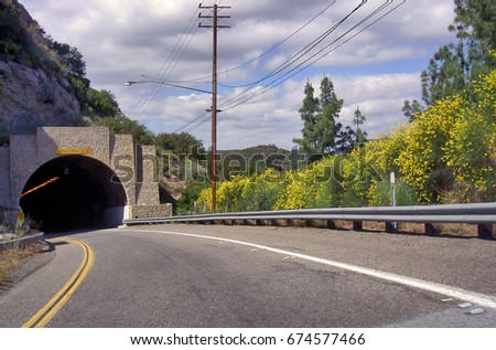 Entrance to Kanan Road tunnel, a Southern California highway surrounded by nature in the Santa Monica mountains recreation area. Royalty-Free Stock Photo #674577466
