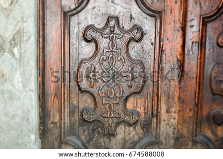 Unique and mysterious door ornament, placed on the old door trough which many years passed. Mysterious door ornament carved in wooden door keep many secrets trough time.