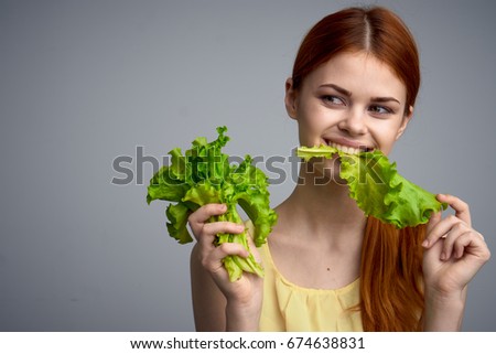 Woman eating lettuce leaves                               