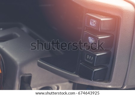 Control panel and the old switch of the car / Dust stick on - off  and power Fog lights  button / black color dashboard of four wheel vehicle / Add Artificial sunshine at above right of image