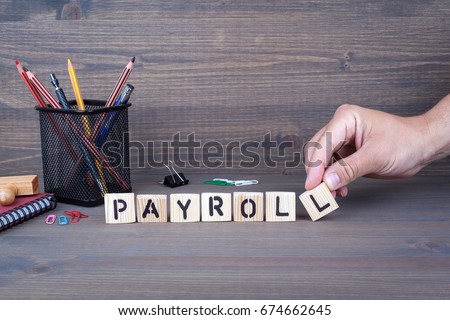 payroll. Wooden letters on dark background Royalty-Free Stock Photo #674662645