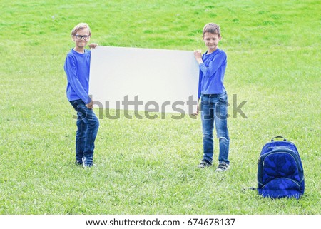 Kids with blank white placard board outdoors