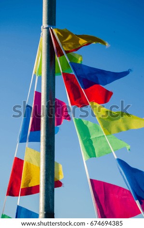 Dangling in the wind festive flags on the background of blue sky