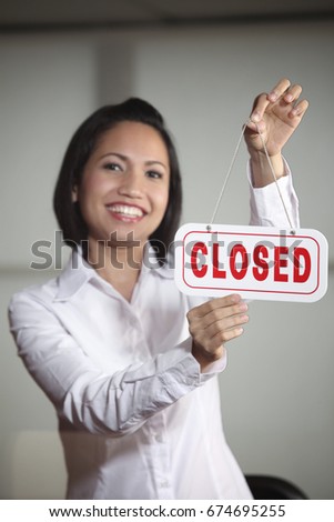 Woman hanging Closed sign 