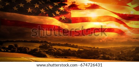 American flag waving on pole against country scene