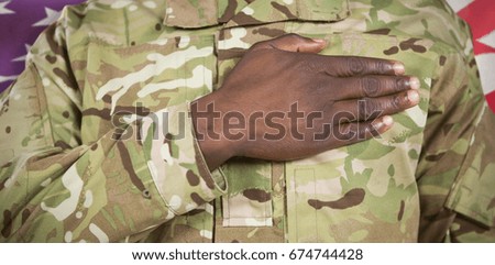 Mid section of soldier taking oath against waving flag of america