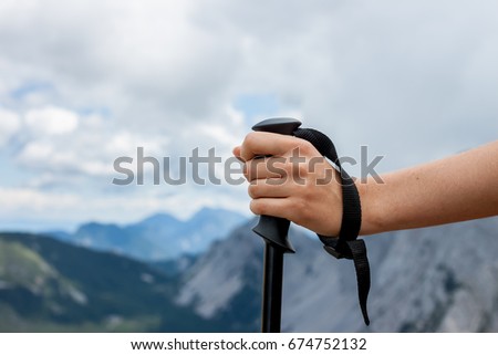 female hand keeping hiking stick