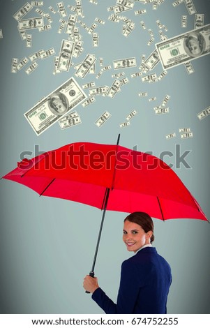 Portrait of smiling businesswoman holding red umbrella against grey background