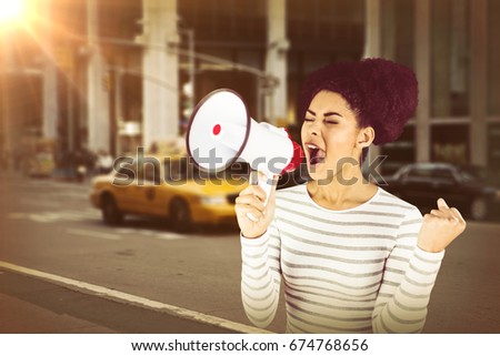 Excited woman shouting with megaphone  against picture of a city