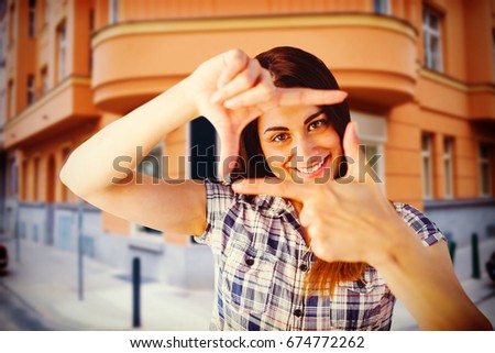 Portrait of woman looking through hands  against entrance of cafe