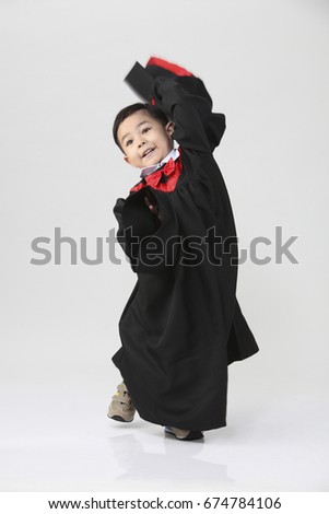 stock image of the boy wearing graduation gown dancing