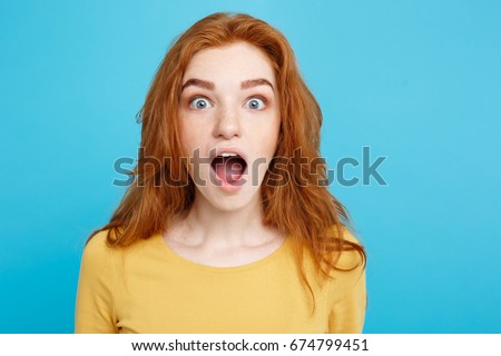 Close up Portrait young beautiful attractive redhair girl shocking with something. Blue Pastel Background. Copy space. Royalty-Free Stock Photo #674799451