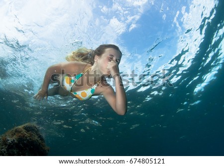 Beautiful girl swims in the sea.