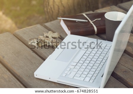Laptop on a wooden pier, near the water. A great place to work or play, especially during the summer. Notepad and coffee