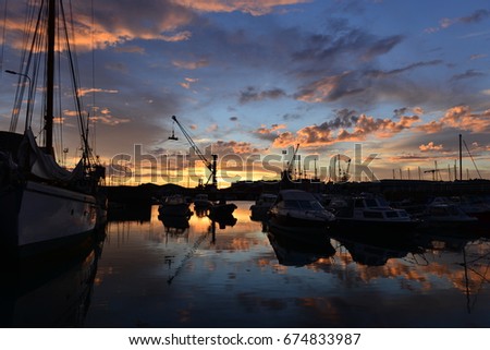 London harbour, Jersey, U.K.  Wide angle image of a dramatic Summer sunset with boats and yachts.