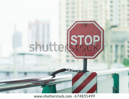 Octagon stop sign at train station with blurred skyscrapers as background, soft and creamy effect