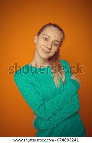 smiling sporty girl. dressed in slinky sportswear. shows exercises. posing in a photo Studio. paper colored background. problem skin and long hair