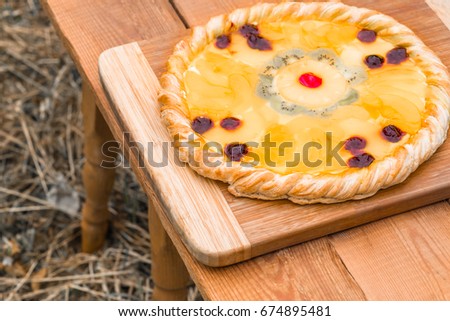 Fruit pizza with pineapple, orange, cherries, cream, jelly, kiwi, home-made isolated on white background closeup