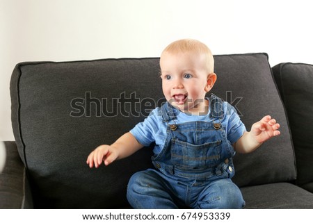 Young blonde boy playing on couch