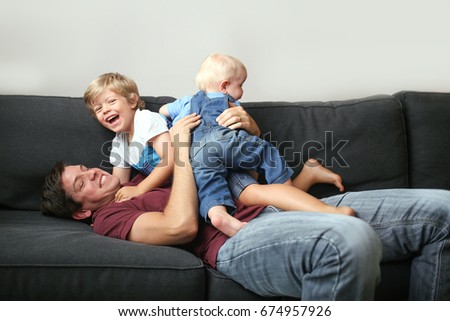 Dad wrestles with sons on the couch