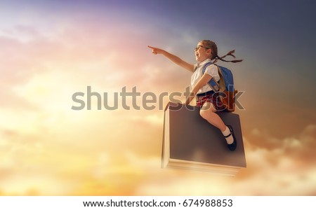Back to school! Happy cute industrious child flying on the book on background of sunset sky. Concept of education and reading. The development of the imagination. Royalty-Free Stock Photo #674988853