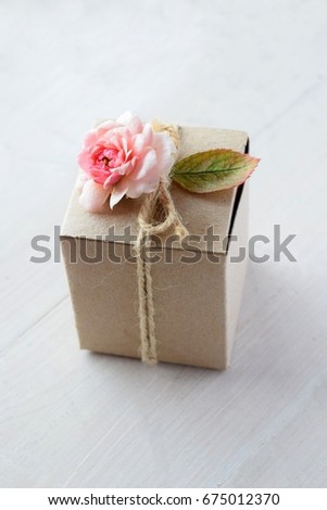 brown gift box with pink rose on white wood background for valentine's day or birthday or wedding anniversary