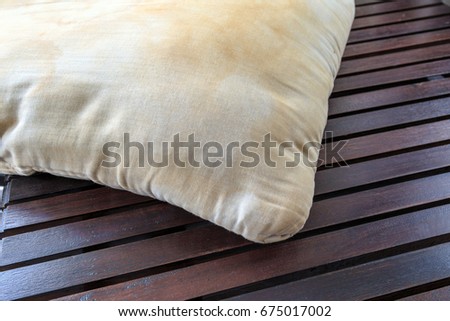 Dirty pillow on wooden table background.