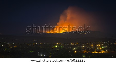 Wildfire burning in the Northern Nevada Hills at night with glow and smoke