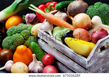 Wooden box with autumn harvest farm vegetables and root crops. Healthy and organic food background. Royalty-Free Stock Photo #675036289