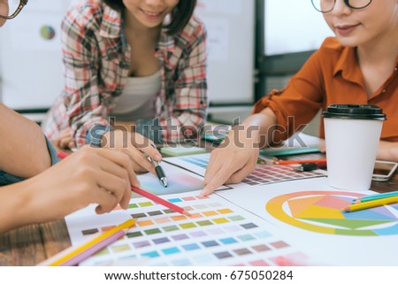 closeup of business people team looking at paper document and discussing design inspiration to choosing color during designer meeting. selective focus photo.